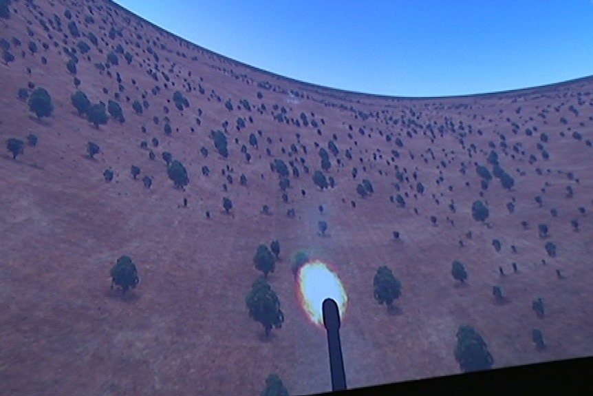 A video screen showing an animation with a missile firing from a plane down to a target on land