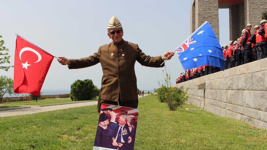 Turkish man Turgut Kamcaz waves Australian and Turkish flags at Gallipoli