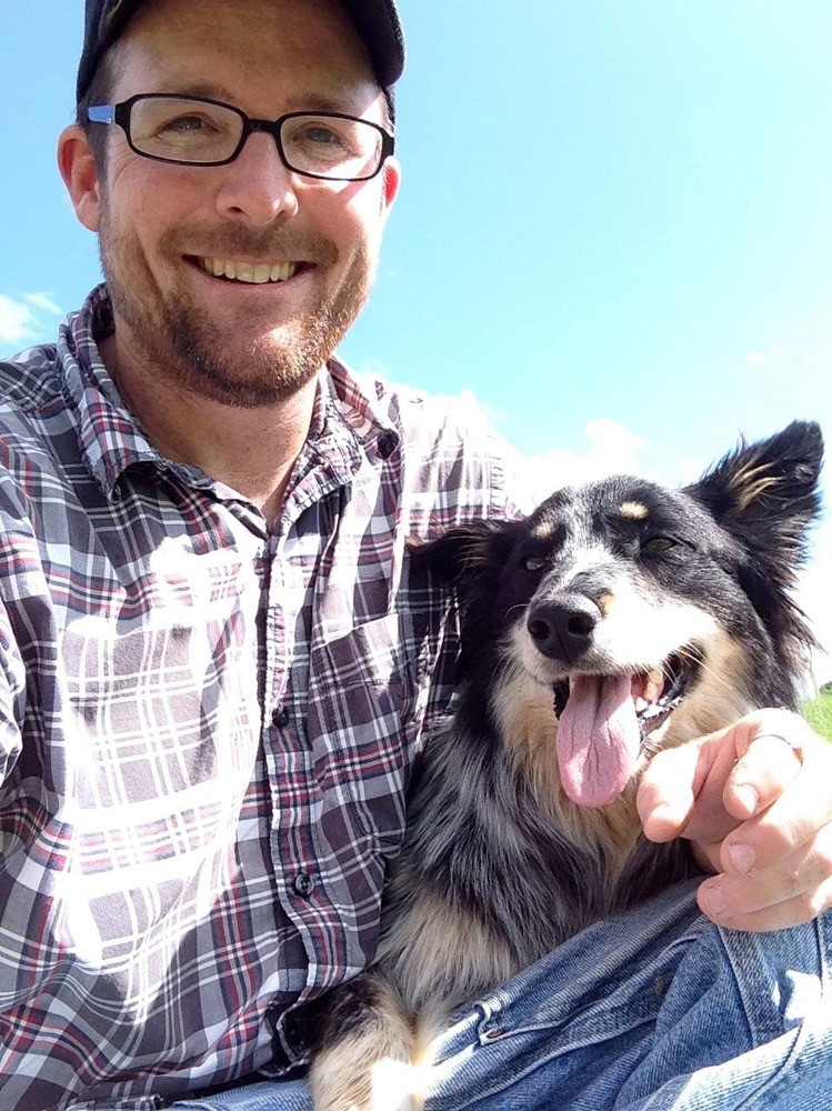 A man smiling at the camera with his dog