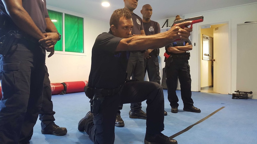 Acting Sgt James Tome demonstrates weapons handling procedures with a replica Glock pistol.