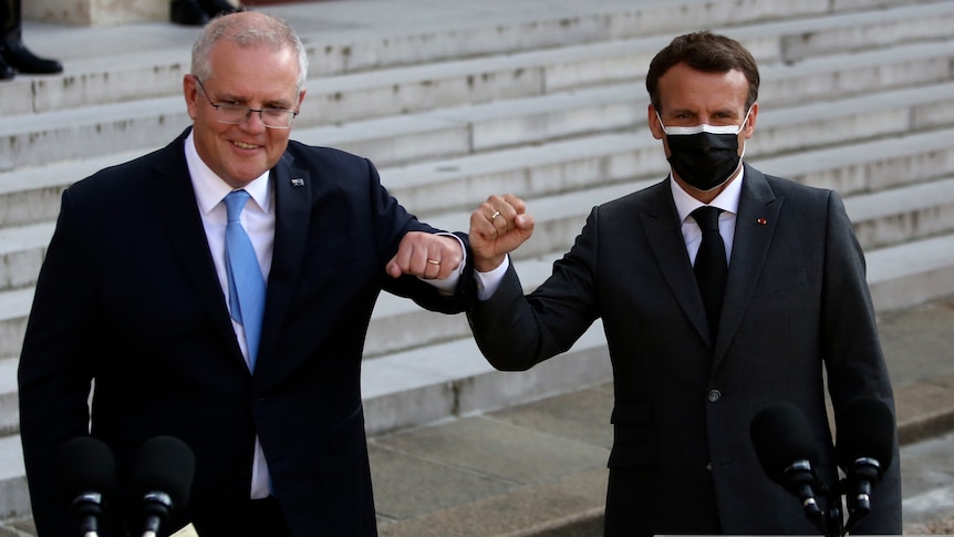 Scott Morrison and Emmanuel Macron bump elbows at a press conference.