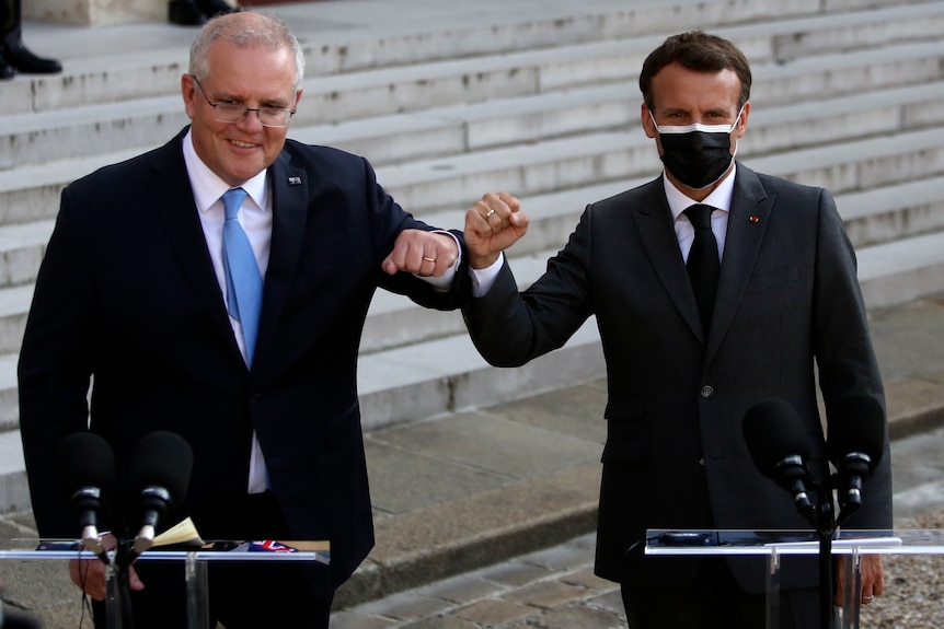 Scott Morrison y Emmanuel Macron golpeándose los codos en una conferencia de prensa.