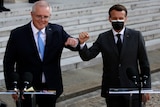 Scott Morrison and Emmanuel Macron bump elbows at a press conference.