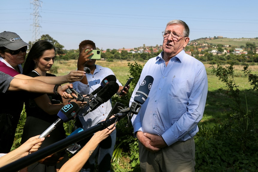 A man speaks to a media pack.