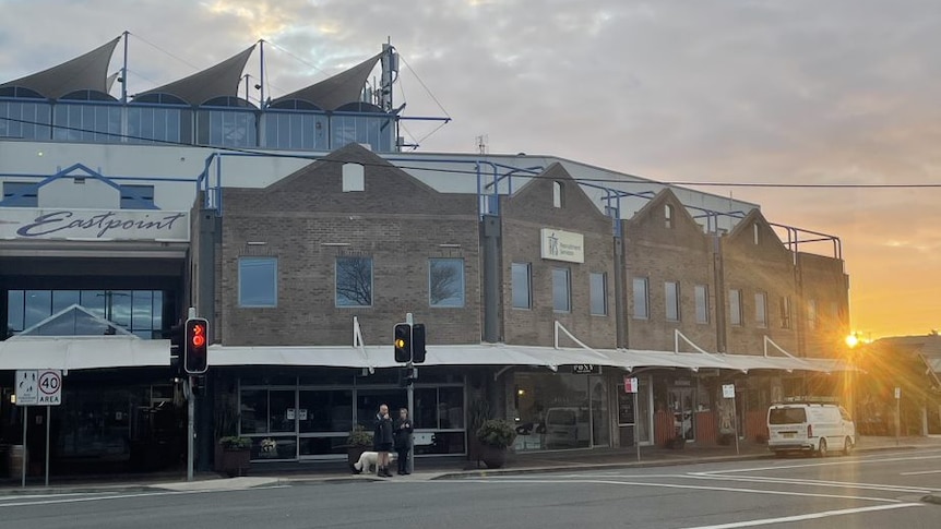 A building in Newcastle with the sun setting behind it. The street is empty.