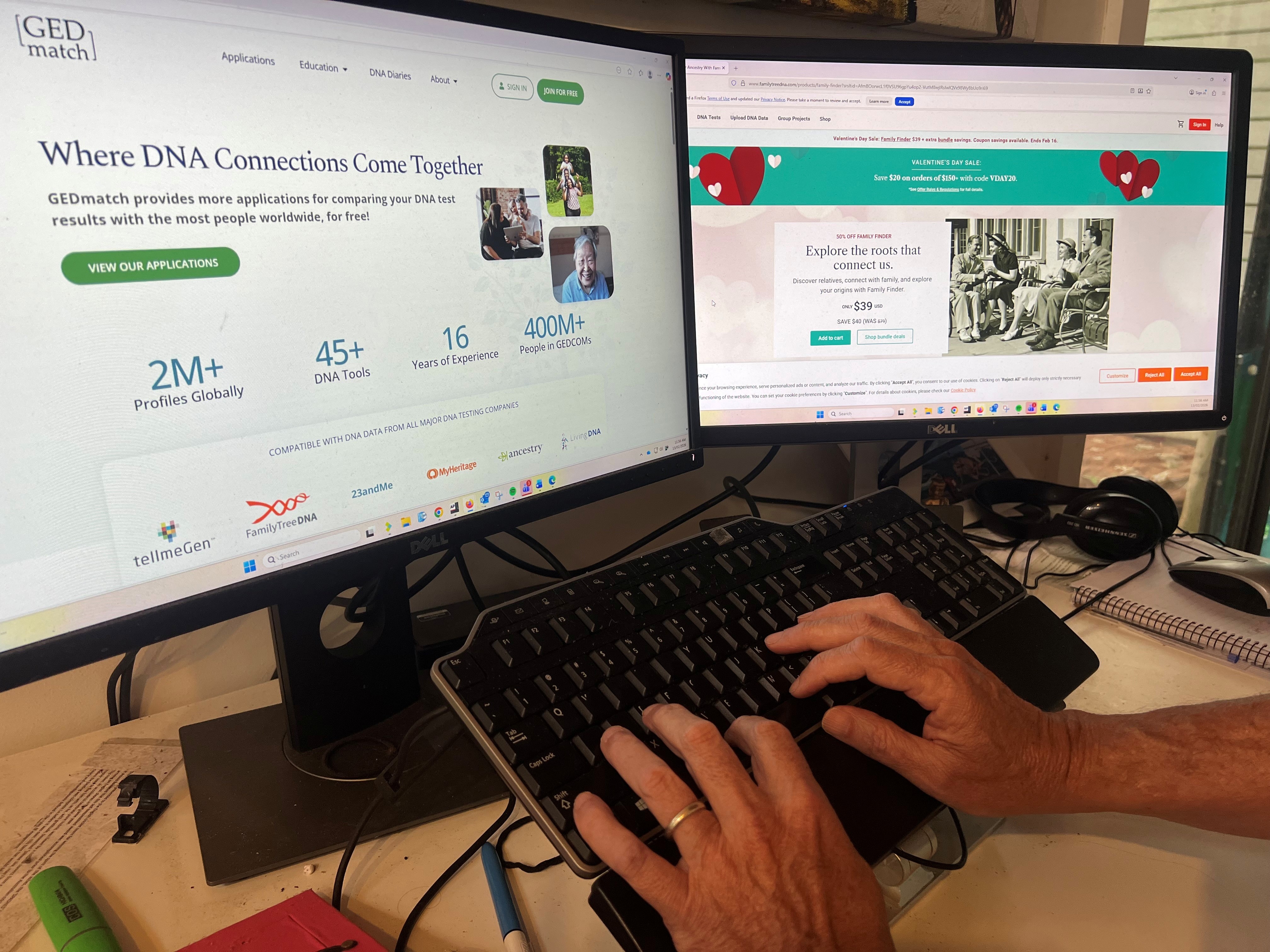 Dedos en un teclado frente a dos pantallas que muestran sitios web de ascendencia.