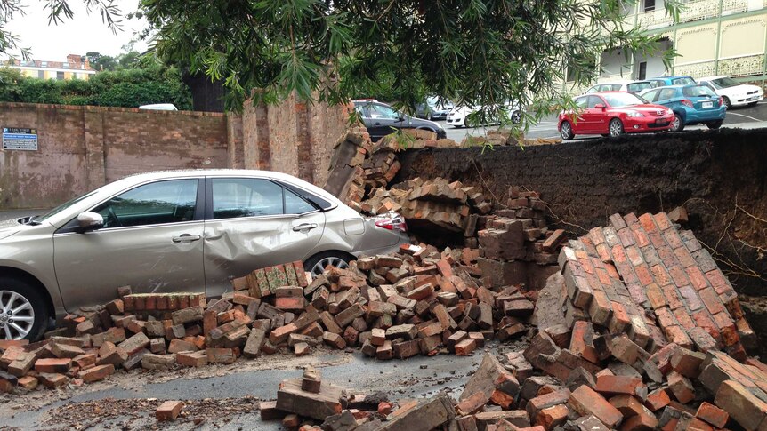 Bricks from a collapsed wall are strewn in a carpark after Tasmania storms