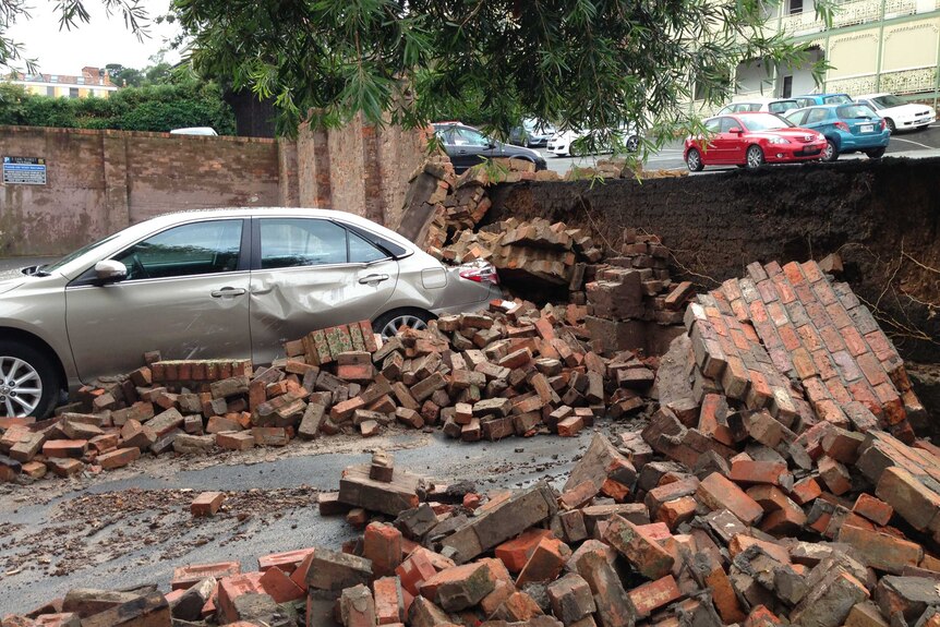 Bricks from a collapsed wall are strewn in a carpark after Tasmania storms