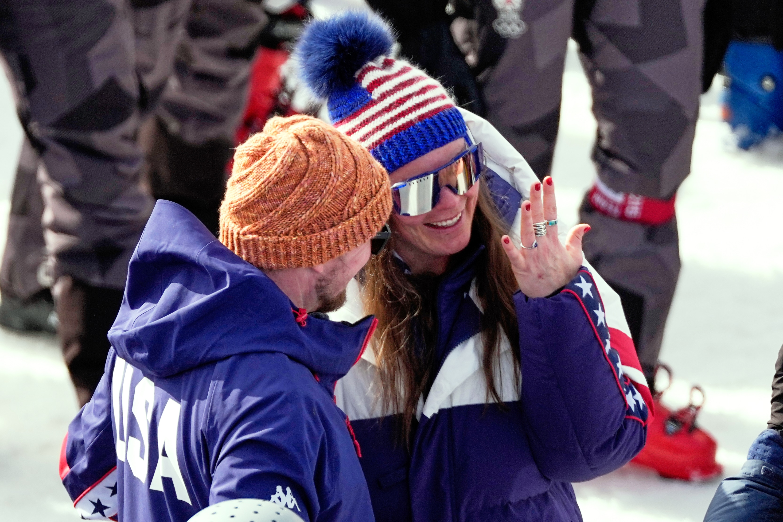 Woman smiles, looking at her hand with a new engagement ring