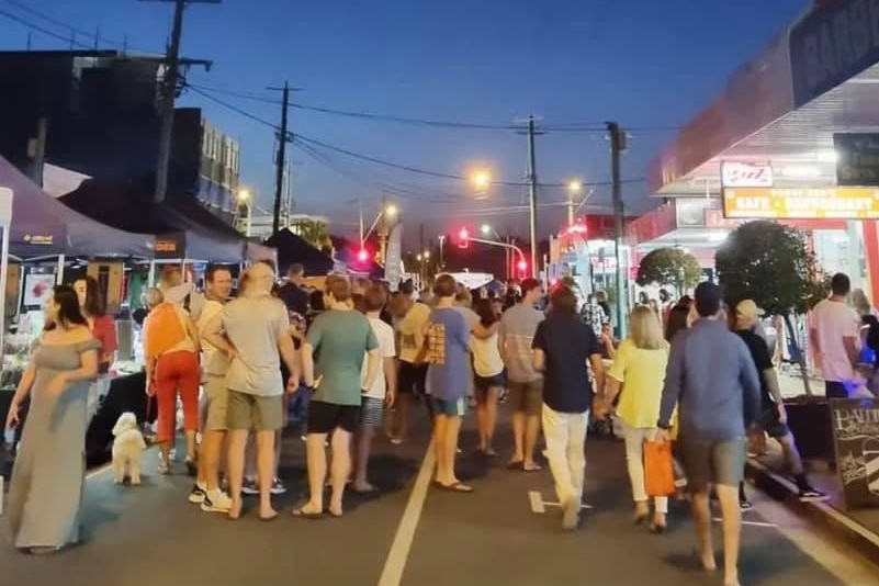 People standing on a street at night. 