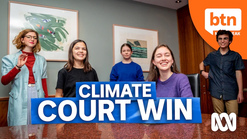 Five teenage students in a boardroom smiling to camera.