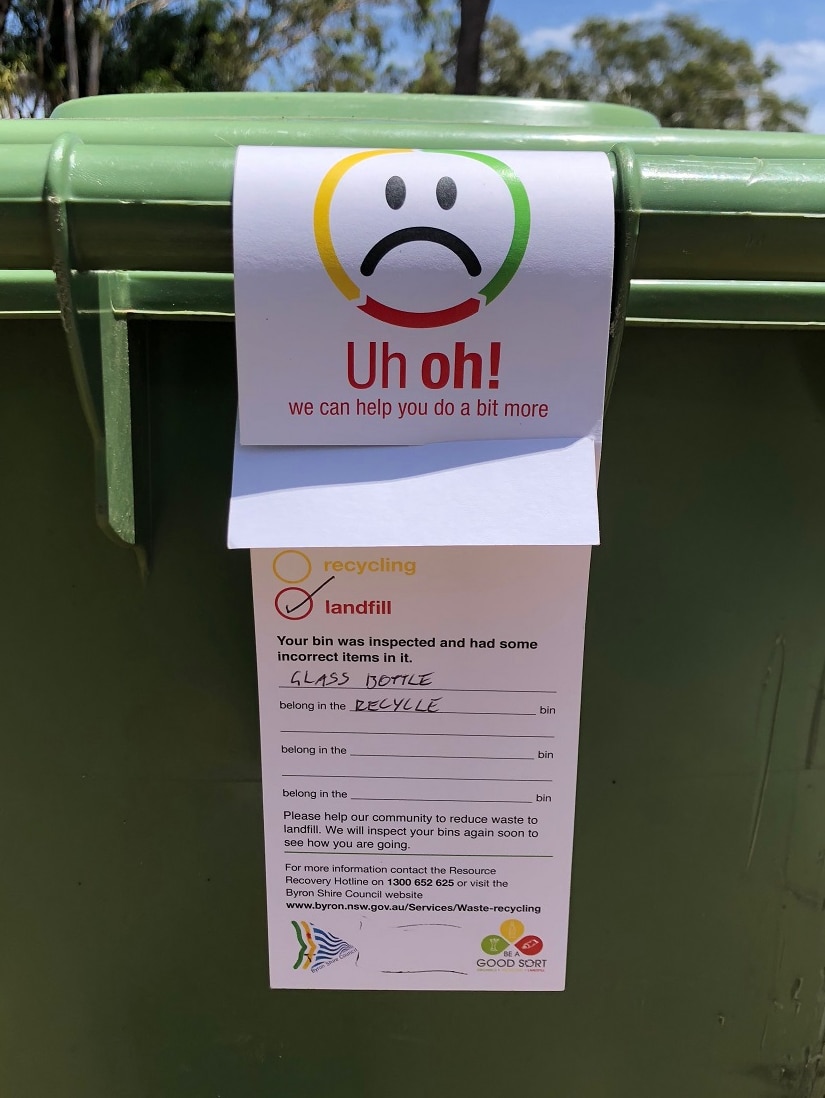 A sad-face sticker on a bin