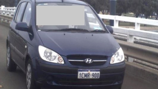 A photo of a blue Hyundai Getz driving on the road, taken from in front of the vehicle.