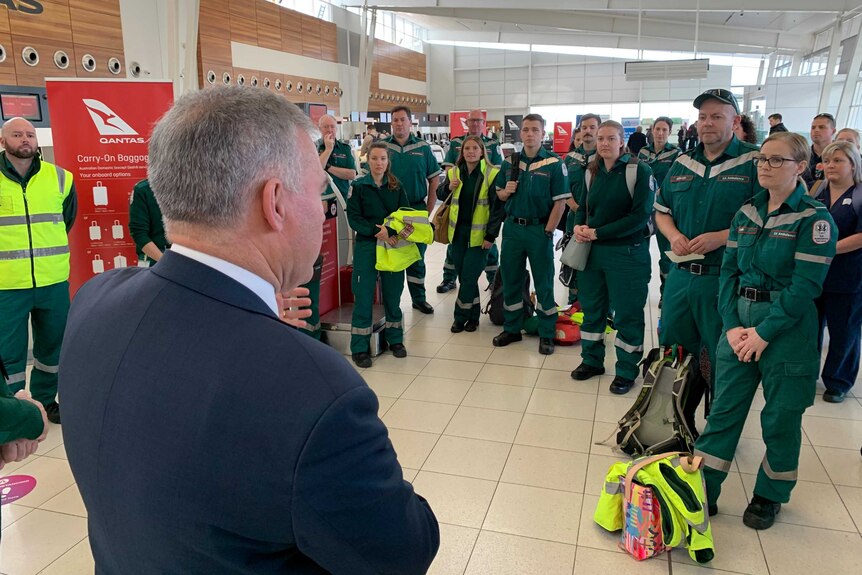 A group of Paramedics dressed in green overalls standing in the Adelaide Airport