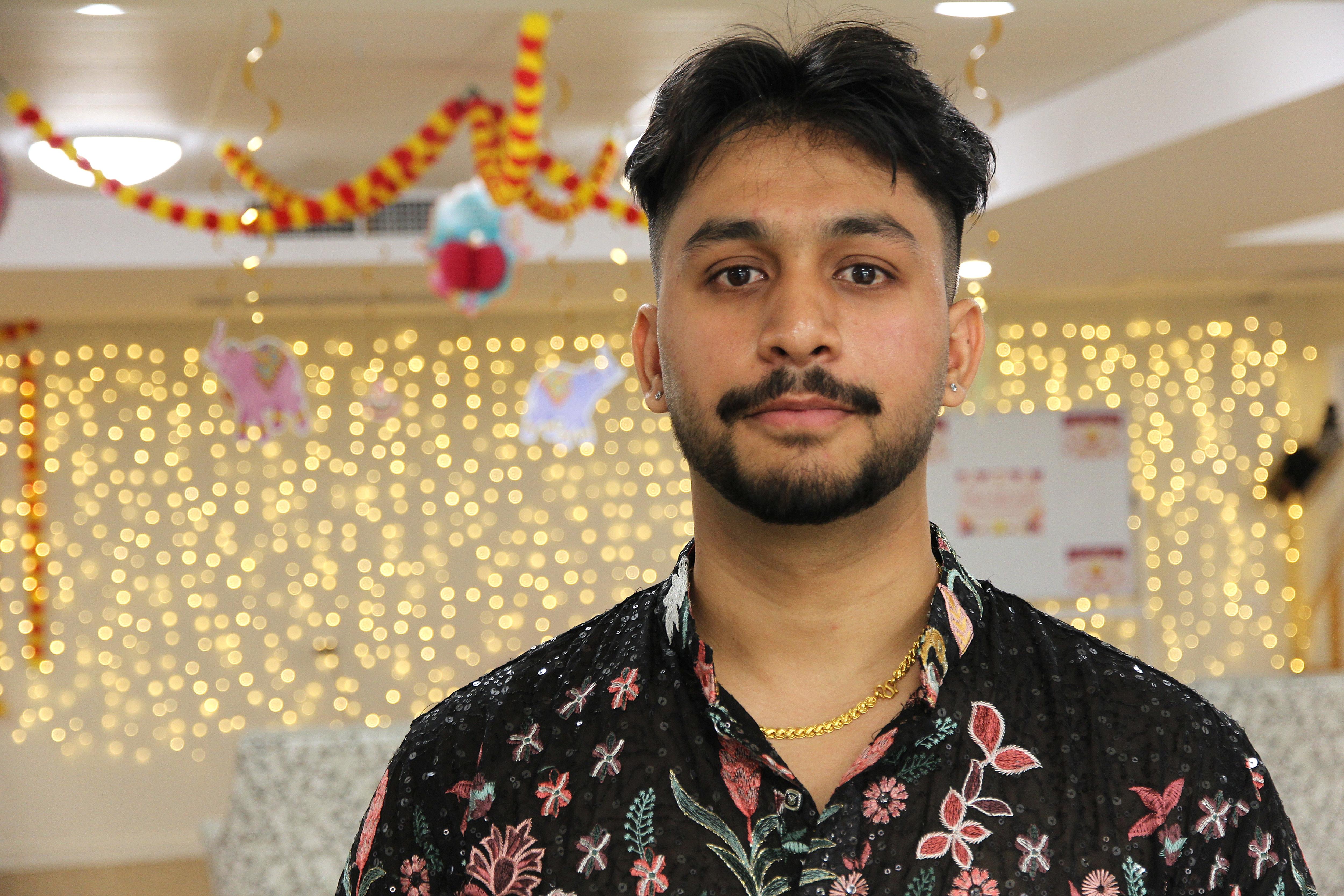 Hombre con camisa floral frente a las luces.
