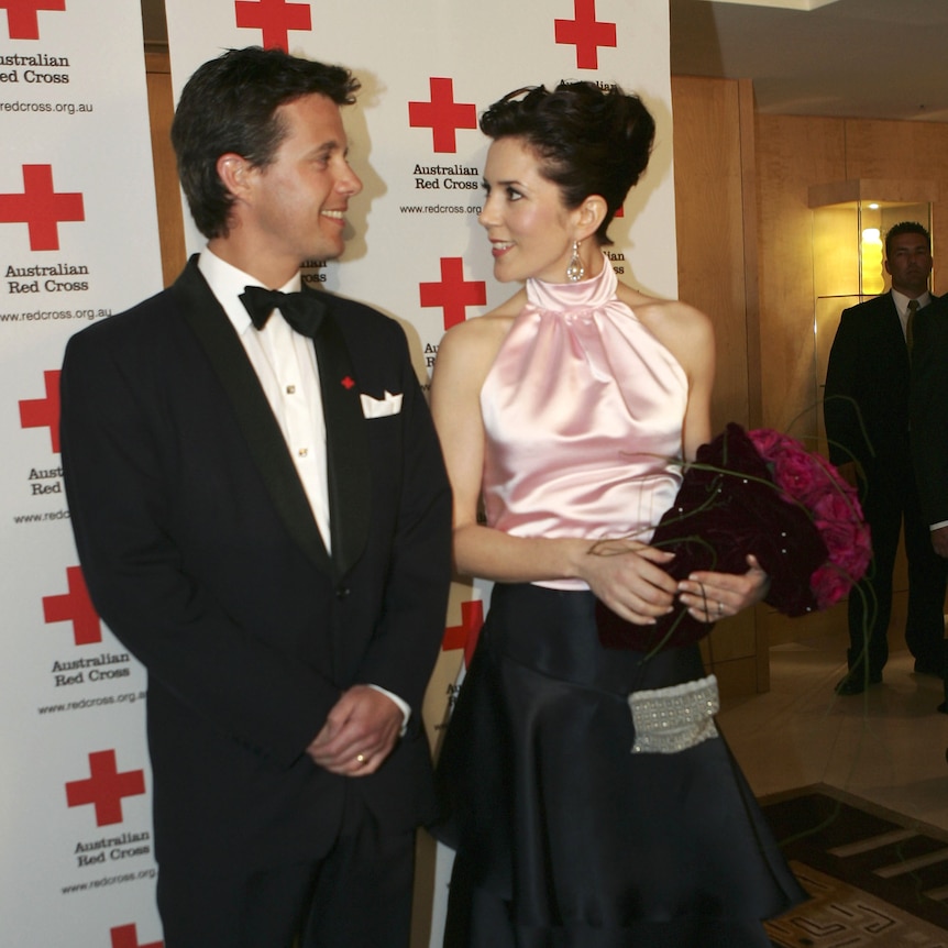 Princess Mary and Danish crown prince Frederik look at each other at event