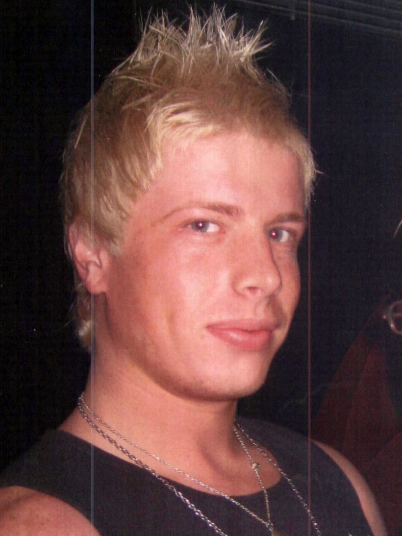 A blonde man looks at the camera