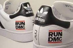 一双阿迪达斯白色球鞋，尾端印着RUN-D.M.C的黑色标识。