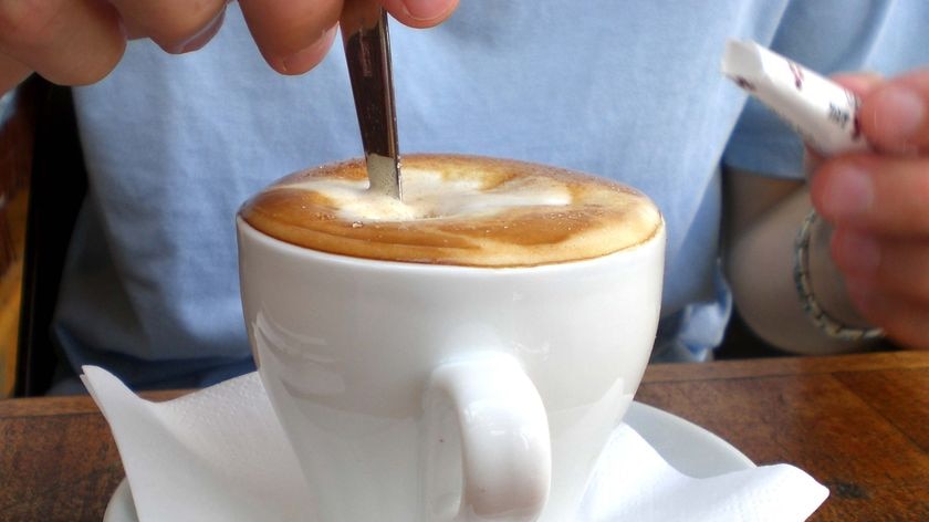 A person stirs their cup of coffee