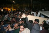 Supporters of Pakistan's assassinated opposition leader Benazir Bhutto unload her coffin.