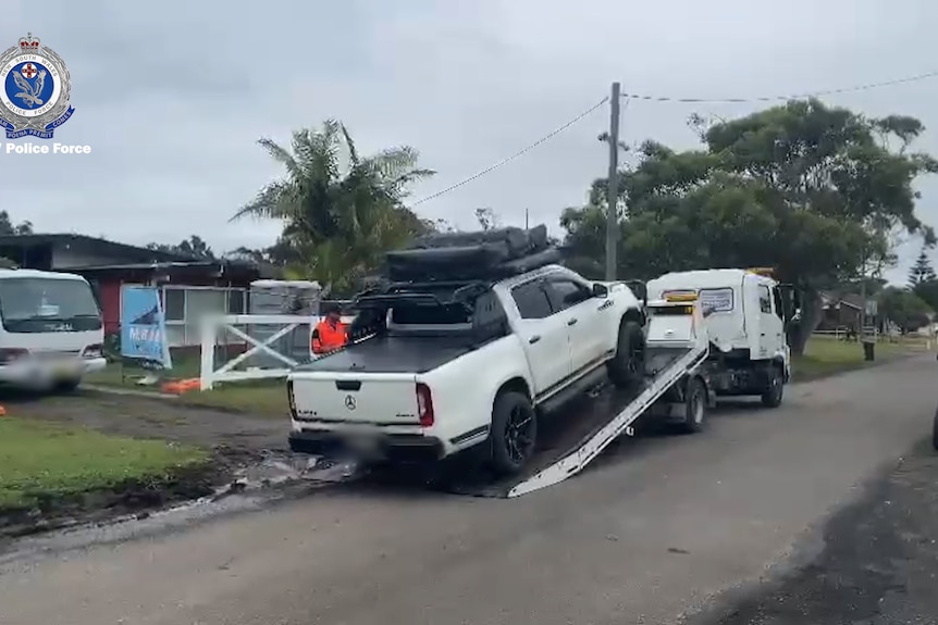 A ute is loaded onto the back of tow truck