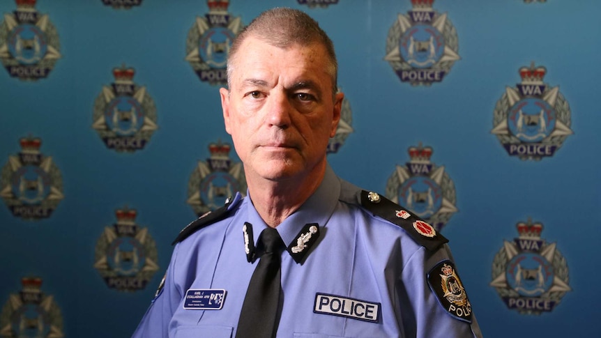 Police commissioner Karl O'Callaghan looks at the camera, with the WA Police logo in the background.