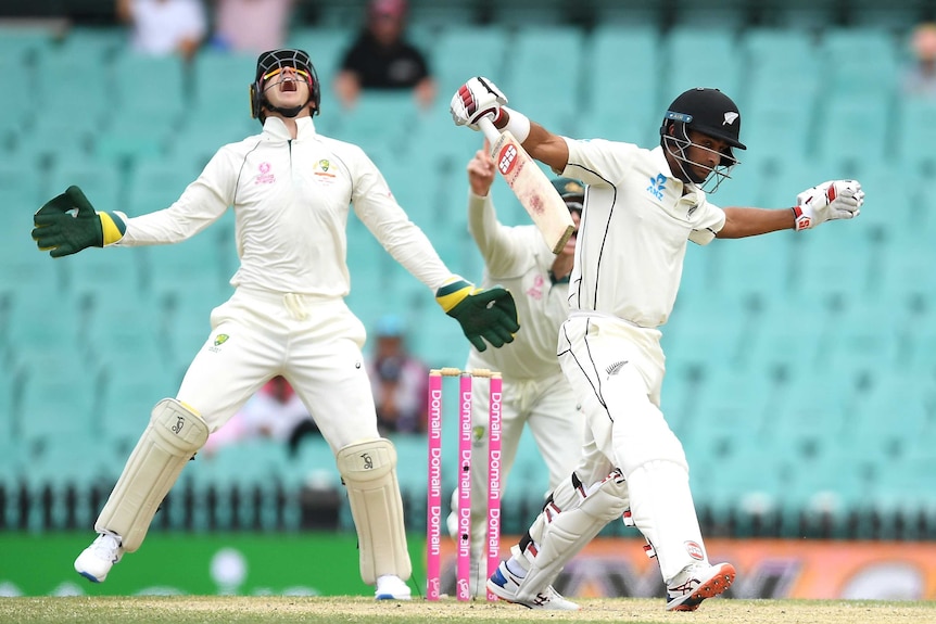 A batsman steps forward as the wicketkeeper looks up after throwing the ball in celebration.