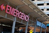 The front of a hospital building featuring signs saying "emergency" and "main entry".