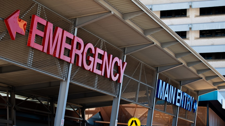 The front of a hospital building featuring signs saying "emergency" and "main entry".