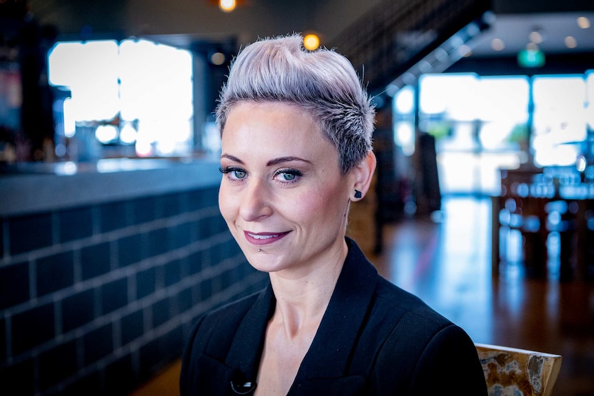 A woman with funky pink hair looking at the camera.