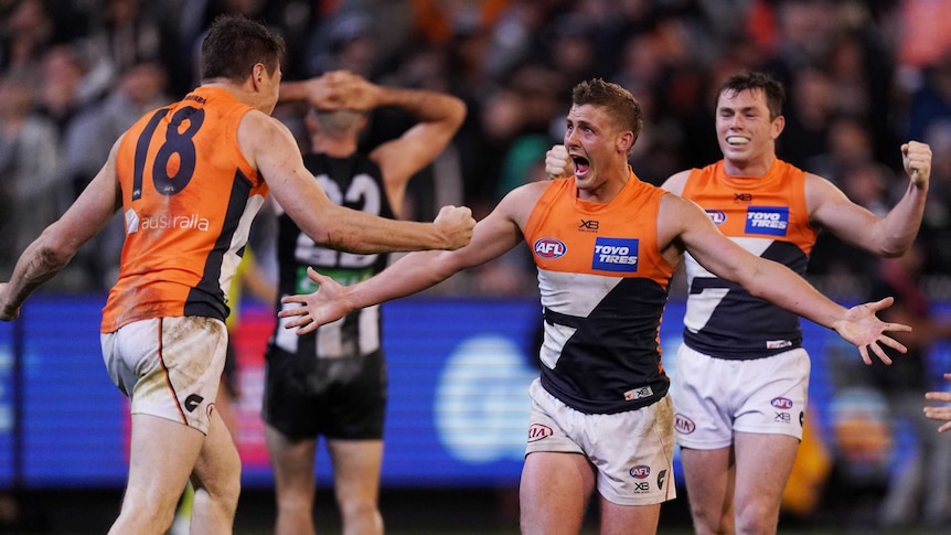 AFL players roar in celebration after a win to put them into the grand final.