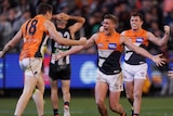 AFL players roar in celebration after a win to put them into the grand final.