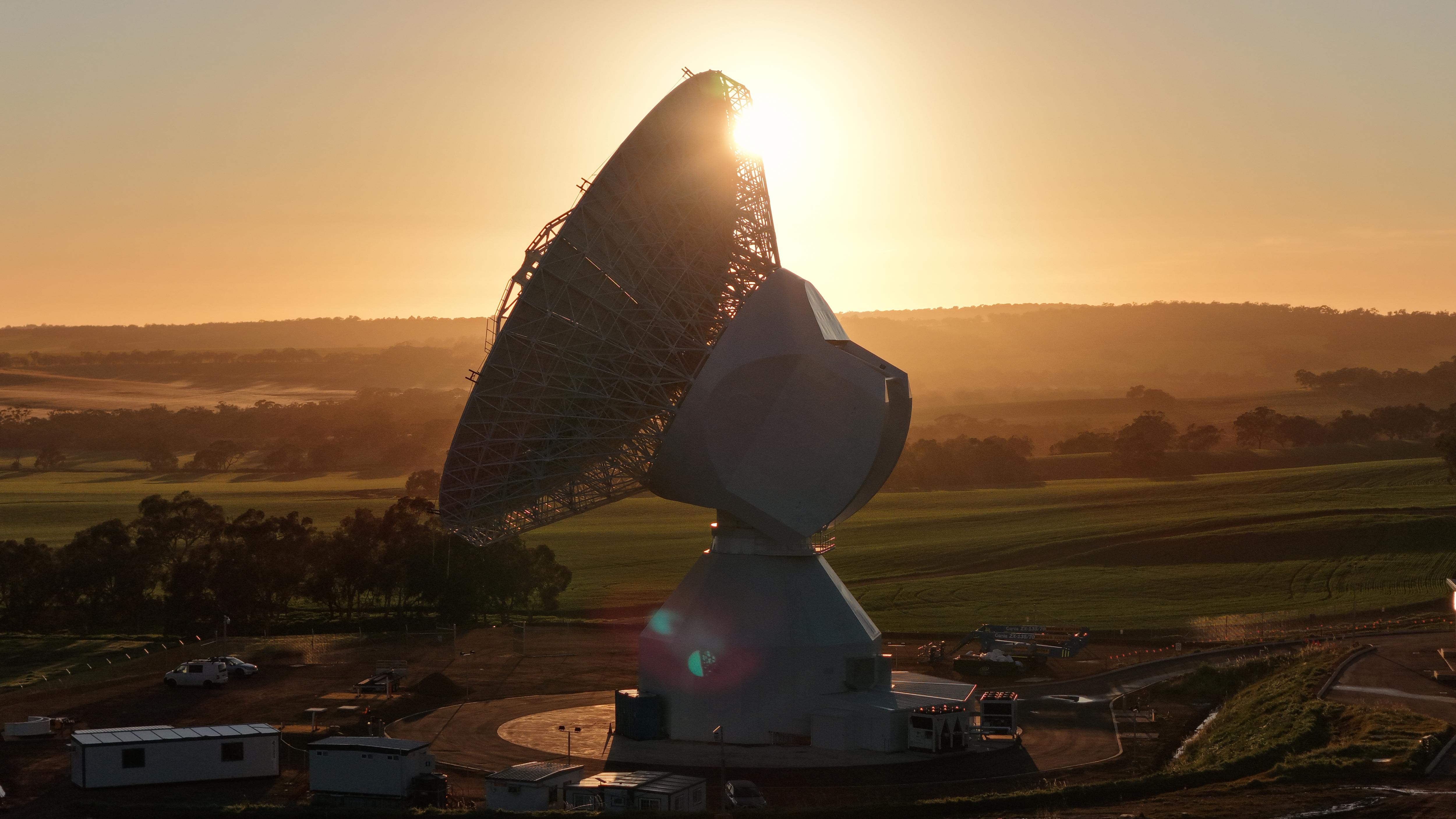 A single large deep space antenna pictured at sunset.