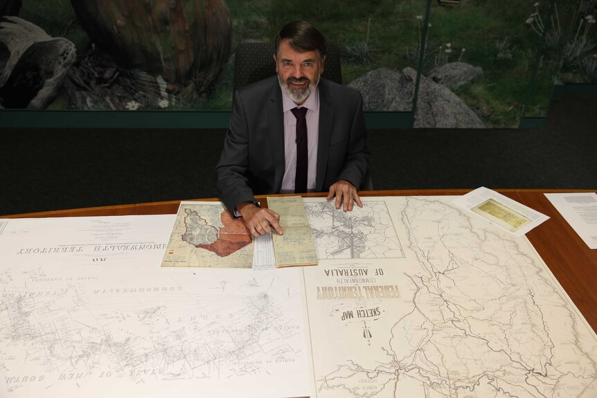 The ACT's Chief Surveyor Jeff Brown with maps and sketches of Canberra