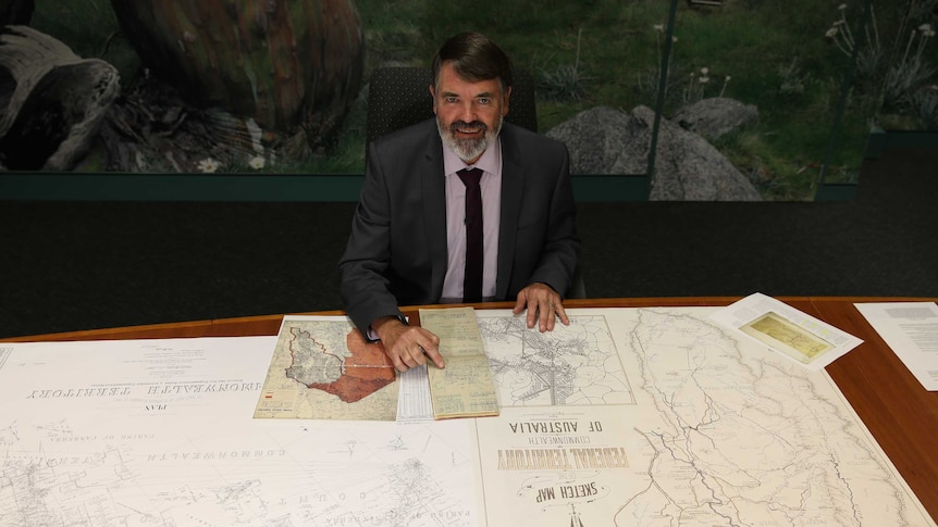 The ACT's Chief Surveyor Jeff Brown with maps and sketches of Canberra
