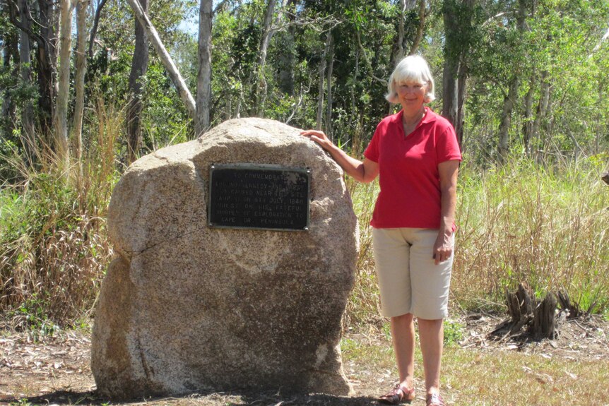 Janet Hauser next to stone plaque