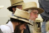 A group of Amish men react to news of a shooting at the Georgetown School in the town of Nickel Mines near Lancaster, Pennsylvania.