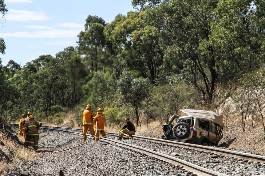 Emergency services on the scene after a car is hit by a train