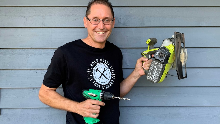 David Paynter from the Gold Coast tool library holds a drill and a circular saw.