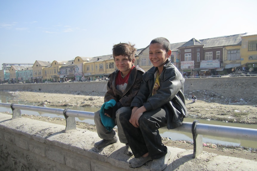 Street boys sit by Kabul River in Afghanistan's capital.