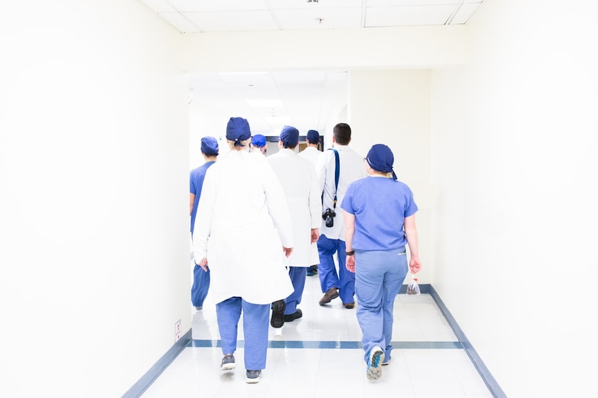 Doctors walking together down a hallway.