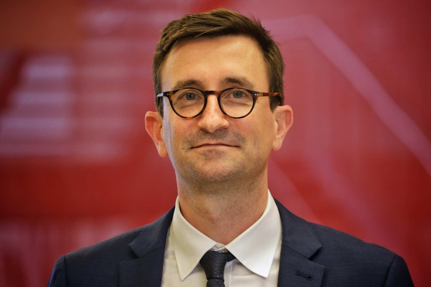 James Daly wears a suit jacket, shirt and tie.