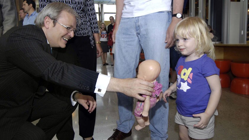Kevin Rudd handing a doll to a little girl