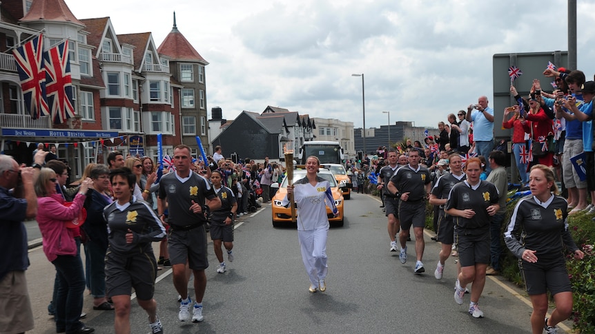 An Olympic torch bearer carries the torch through Newquay in south-west England.