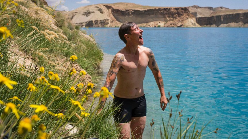 Eddie Ayres stands next to a body of water in Afghanistan after having gone for a swim.