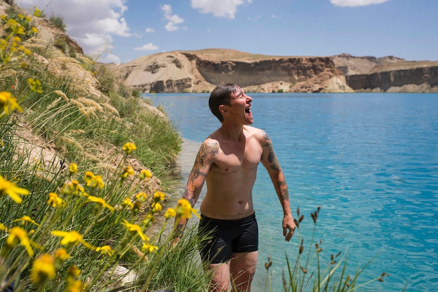 Eddie Ayres stands next to a body of water in Afghanistan after having gone for a swim.