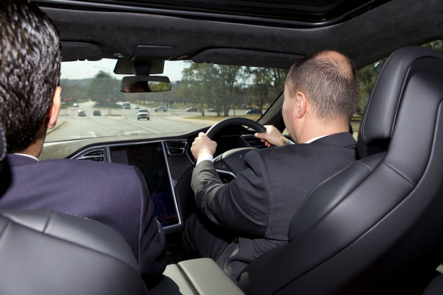 Josh Frydenberg is seen from the back seat taking a Tesla Model S electric car for a test drive around Canberra.