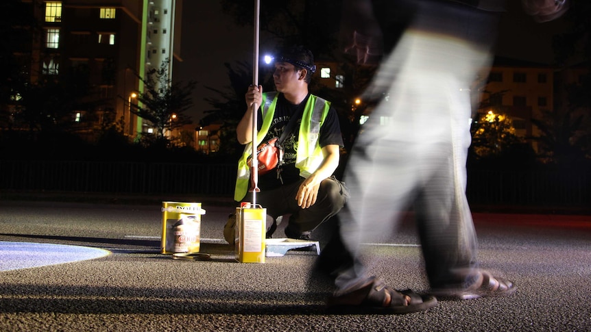 A man helps repair a Malaysian road.