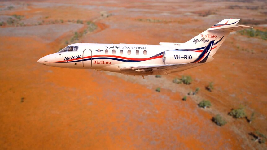 RFDS jet in the air, red dirt in the background.