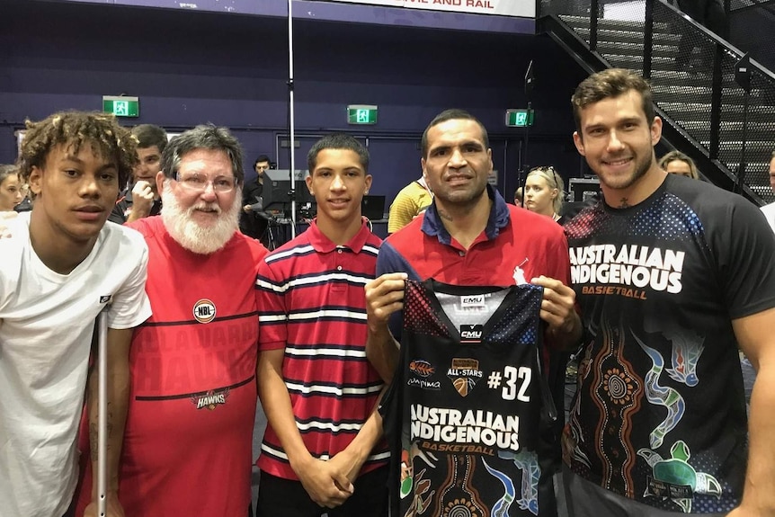 Anthony Mundine and Tyson Demos pose for a photo with an indigenous basketball jersey